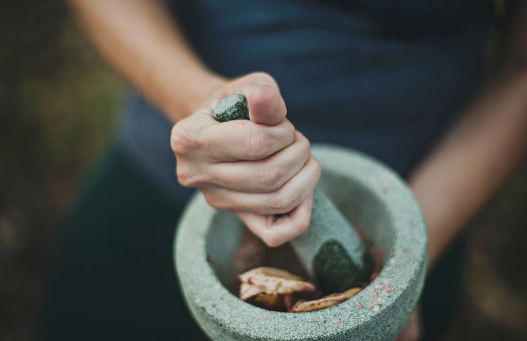 Woman grinding herbs in a mortar and pestle