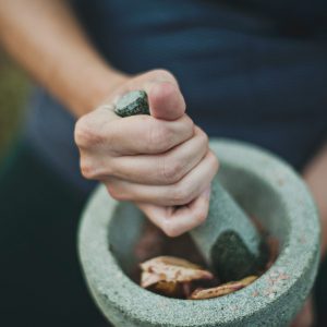 Woman grinding herbs in a mortar and pestle